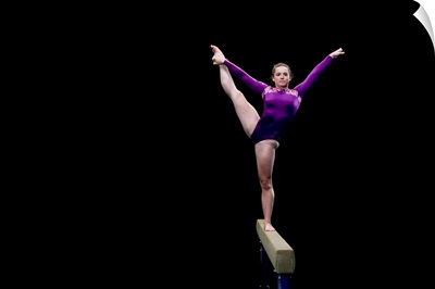 Female gymnast performing on the balance beam