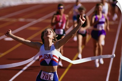 Female runner victorious at the finish line in a track race
