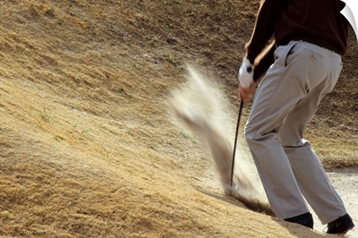 Golfer blasting out of sand trap