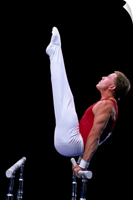 Male gymnast performing on the parallel bars