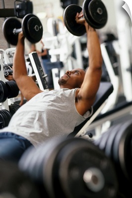 Male working out with weights in a health club