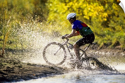 Mountain biker riding through a stream