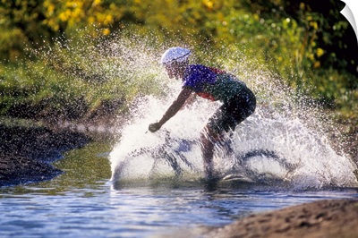 Mountain biker riding through a stream