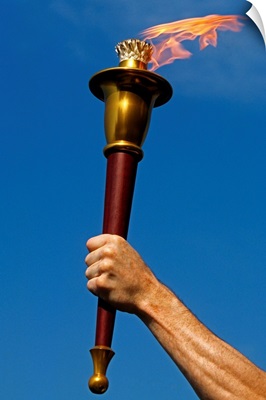 Photograph of mans hand holding ceremonial torch