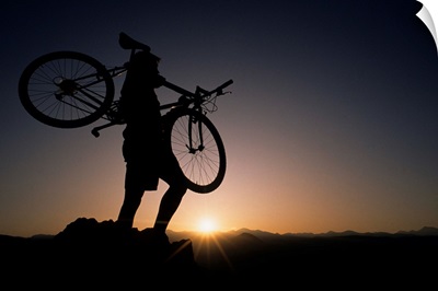 Silhouette of cyclist at sunrise