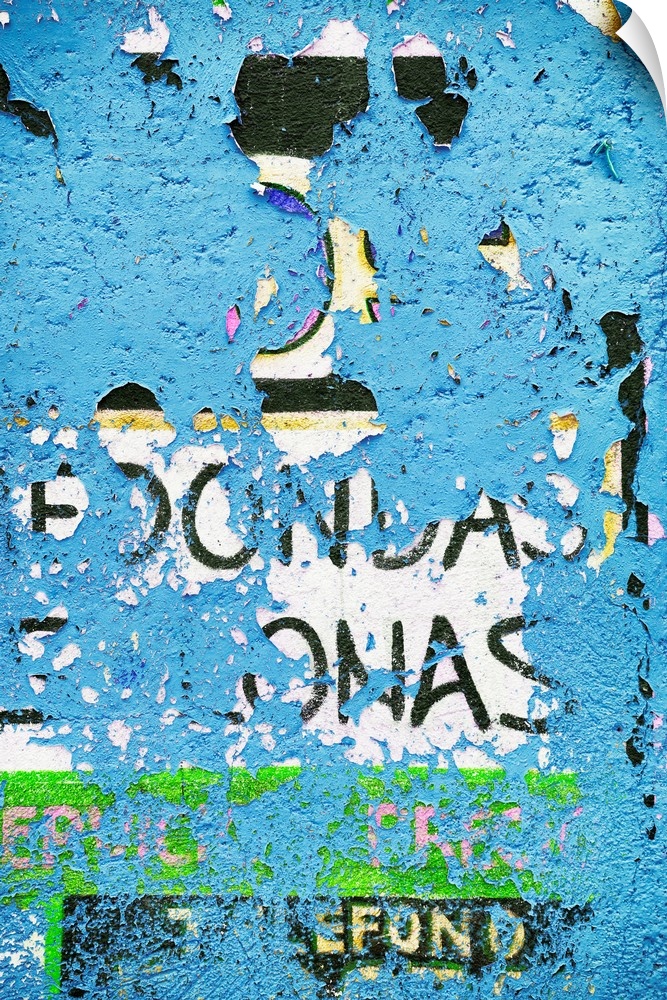 Photograph of peeling blue street art paint, revealing old text. From the Viva Mexico Collection.