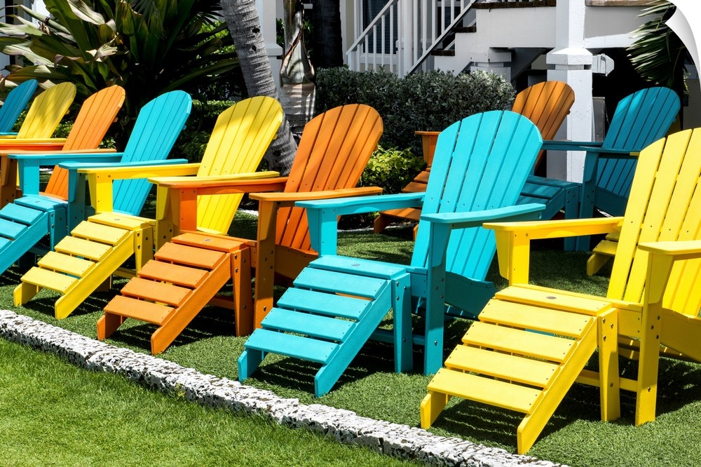 A collection of brightly painted Adirondack chairs.