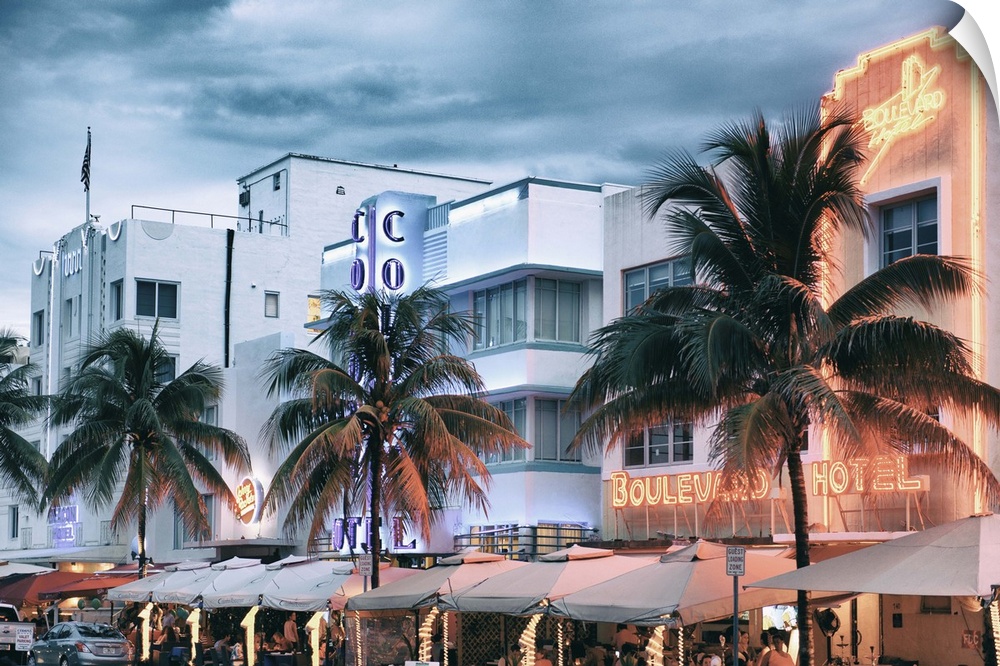 The buildings on Ocean Drive in Miami framed by palm trees and lit with neon lights.