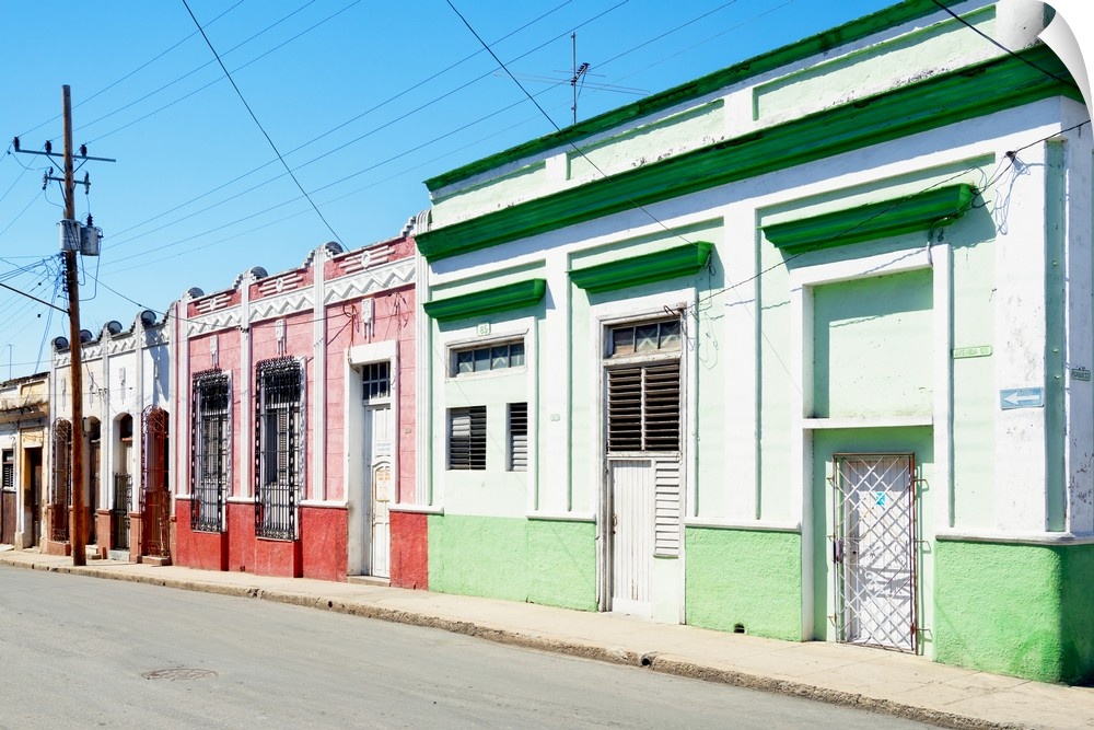 Photograph of a Havana streetscape with colorful facades lining the road.