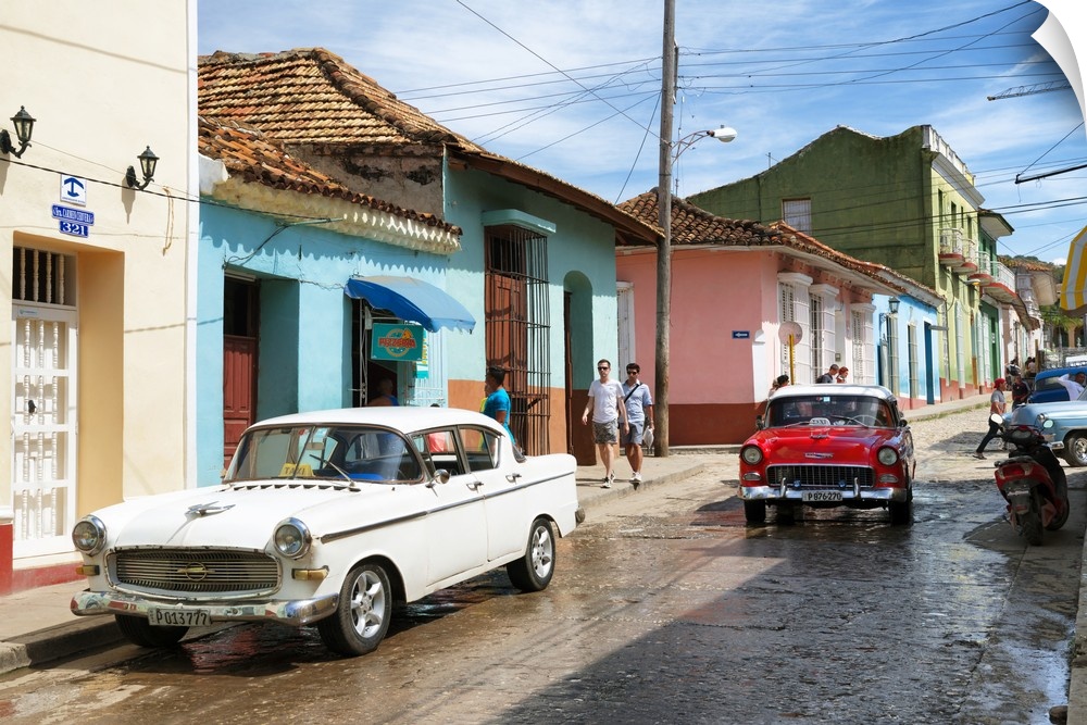 Photograph of a busy Cuban street scene with vintage cars.