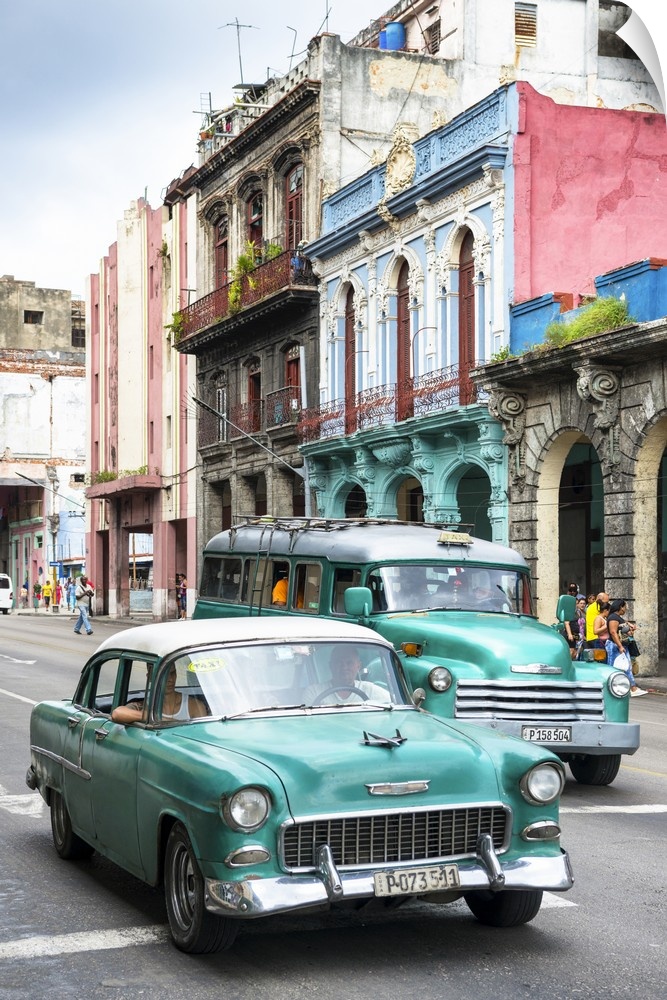 Photograph of two green vintage Chevrolets in a Havana street scene.