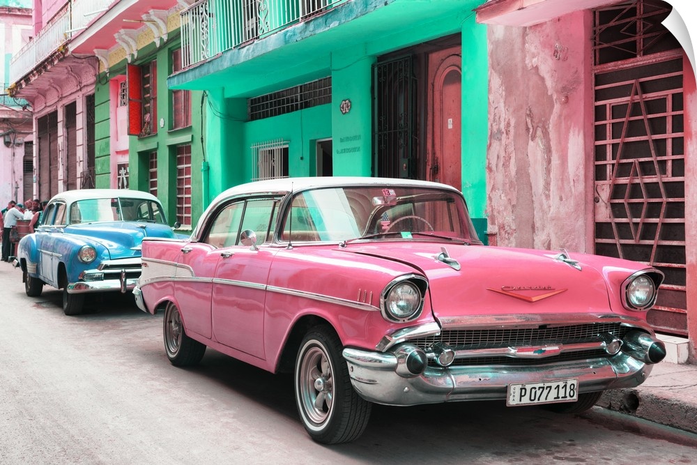 Photograph of a pink Chevrolet parked outside of brightly colored Cuban facades.