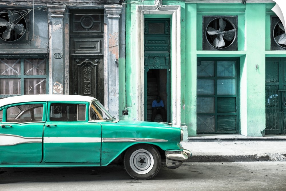 Photograph of a classic old red car in front of a pink facade in Havana, Cuba.