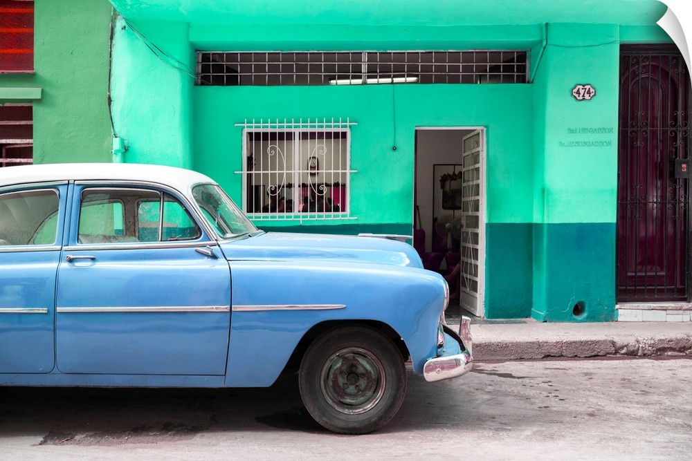 Photograph of a blue vintage car parked on the road in Havana.