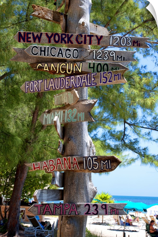 A wooden signpost full of signs showing the distances to many cities.