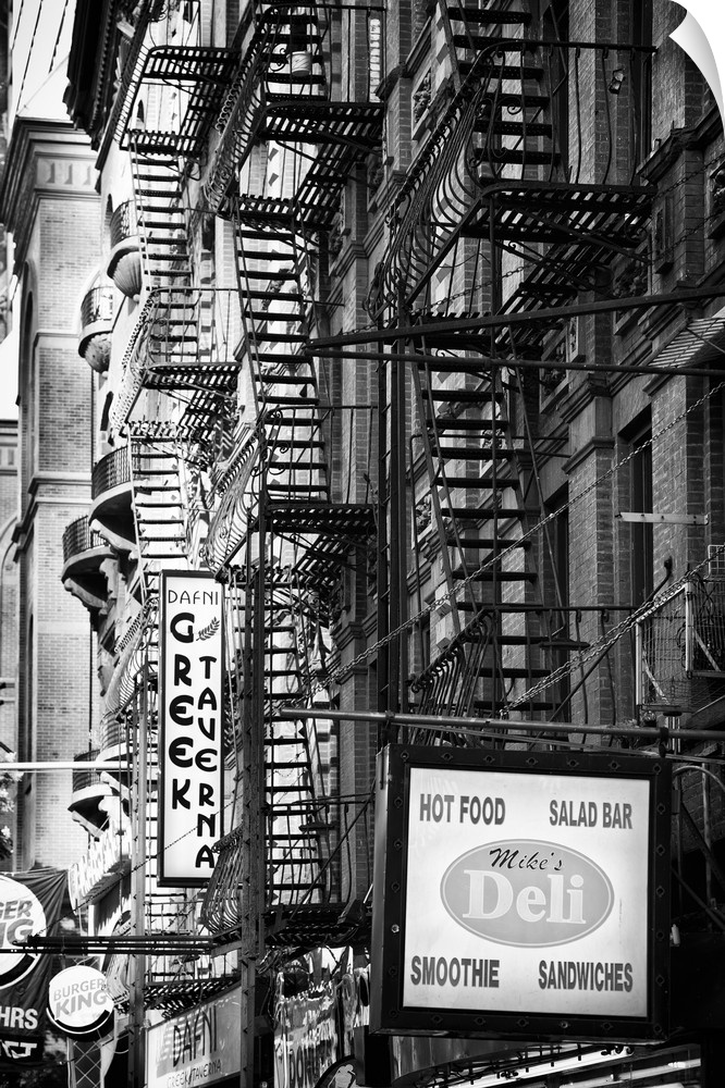Black and white photo of several fire escapes on the sides of buildings in Manhattan.