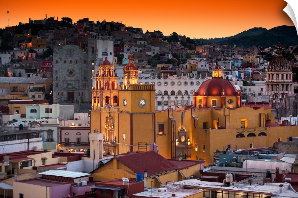 Photograph of a Guanajuato cityscape featuring the iconic Yellow Church at twilight under orange skies. From the Viva Mexi...