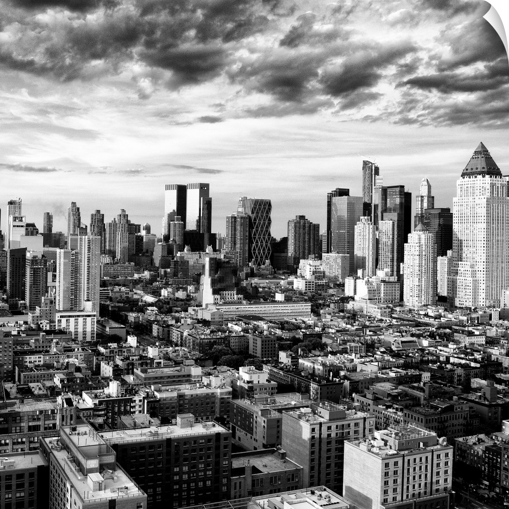 A black and white photo of the New York City skyline under dramatic clouds.