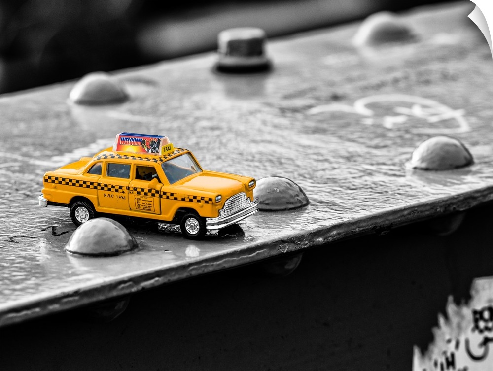 A photograph of a toy taxi cab sitting on a steel beam on the Brooklyn bridge.