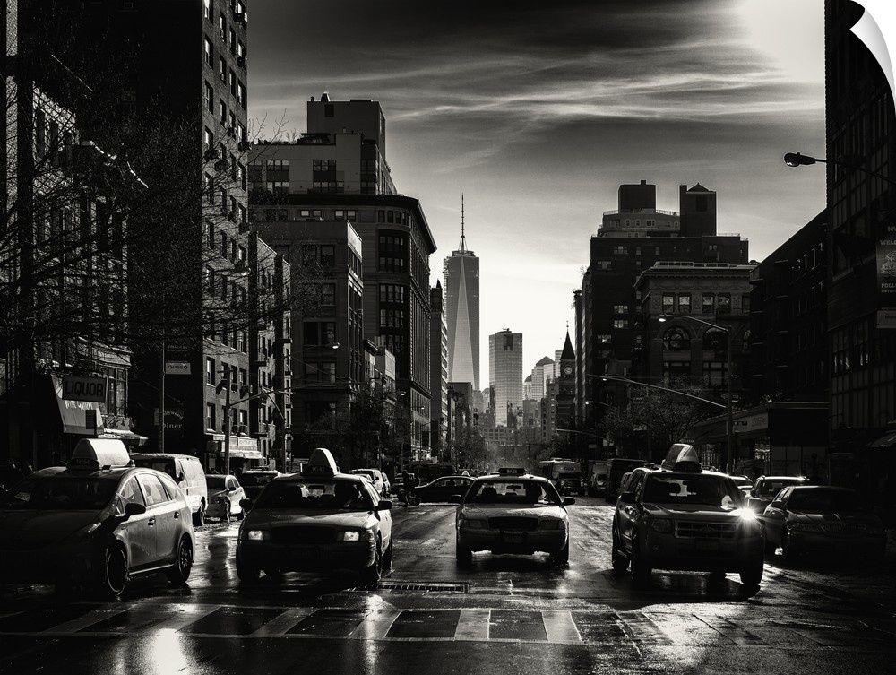 A black and white photograph of New York city at night with yellow taxis everywhere.