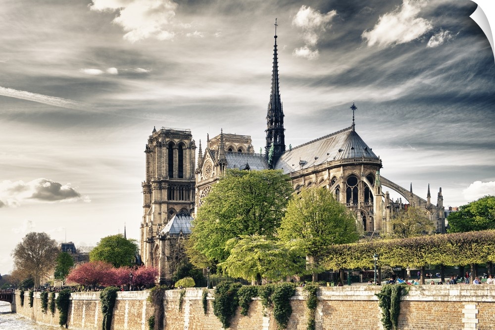 Fine art photo of the Notre Dame Cathedral under a cloudy sky.