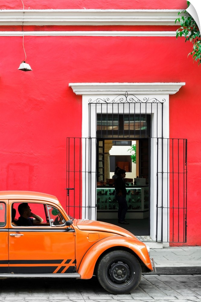 Photograph of a classic orange Volkswagen Beetle in front of a red building, Mexico. From the Viva Mexico Collection.