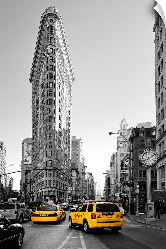 Fine art photo of the Flatiron Building, seen from the street, with yellow taxi cabs.