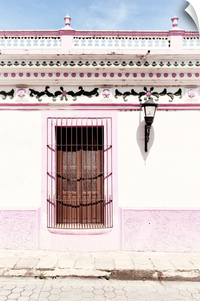 Photograph of a pink and white exterior to a building with detailed designs above the window. From the Viva Mexico Collect...