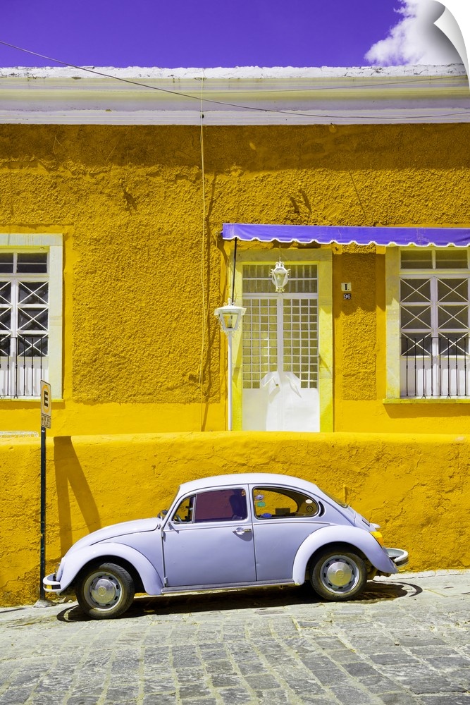 Photograph of a classic Volkswagen Beetle in front of a yellow and purple building. From the Viva Mexico Collection.