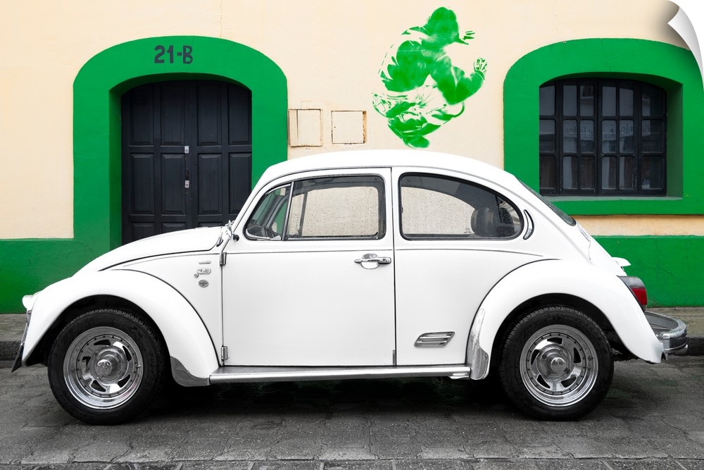Photograph of a classic white Volkswagen Beetle parked in front of a building with a green trim wall and green graffiti. F...