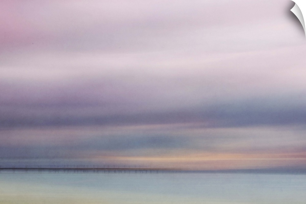 Photograph of a seascape under a blanket of smooth pale purple clouds.