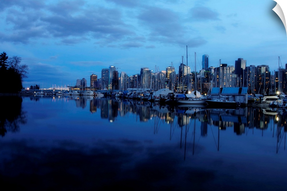 A pretty view of the Vancouver yacht club and downtown skyline at night.