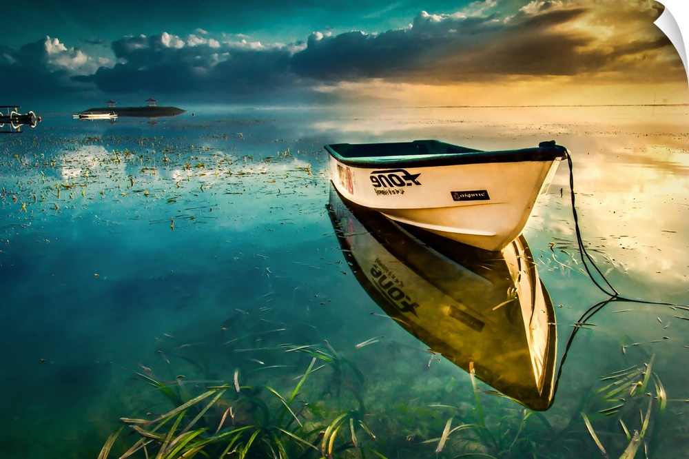 A lone row boat lays still in flat reflective water casting perfect reflection.