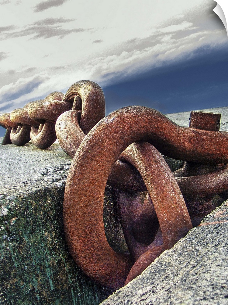 A large, rusted chain on concrete at a dock.