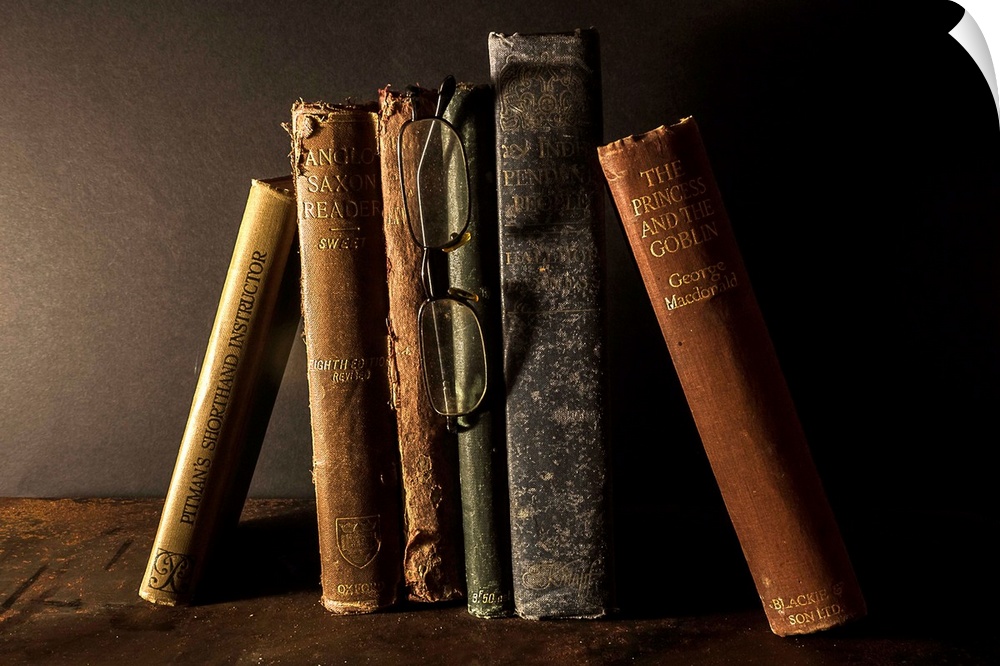 A collection of old, worn books leaning together.