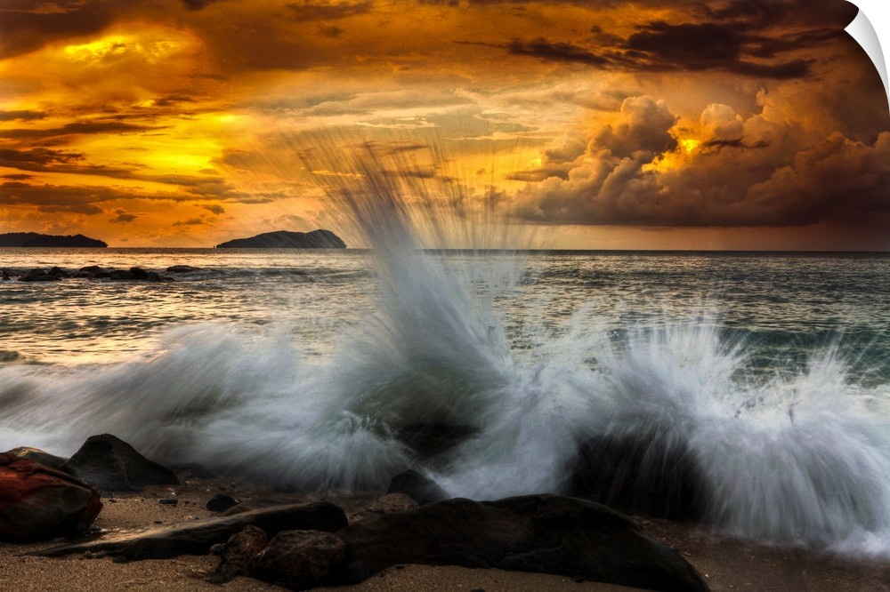 Waves crashing on the rocky shore at sunset.