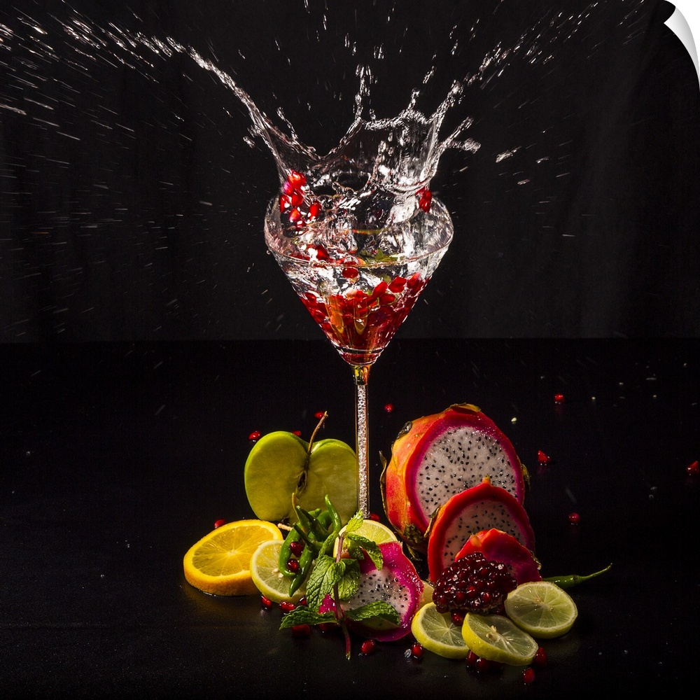 Fruit splashing into a glass of liquid.