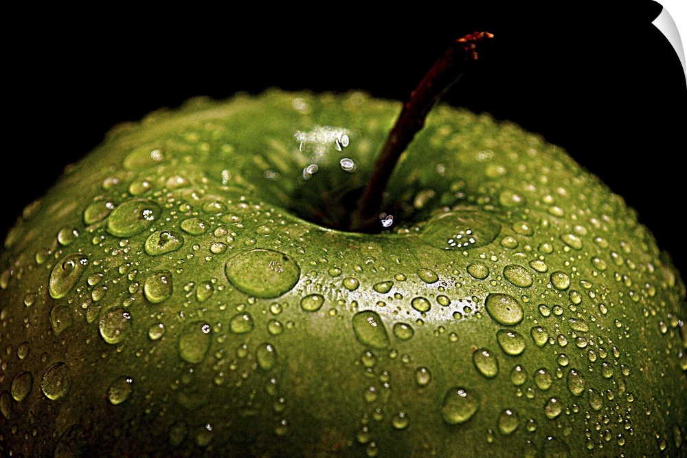 A bright green apple covered in water droplets.