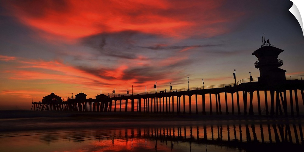 Huntington Beach Pier, California, at sunset, with bright red clouds above.