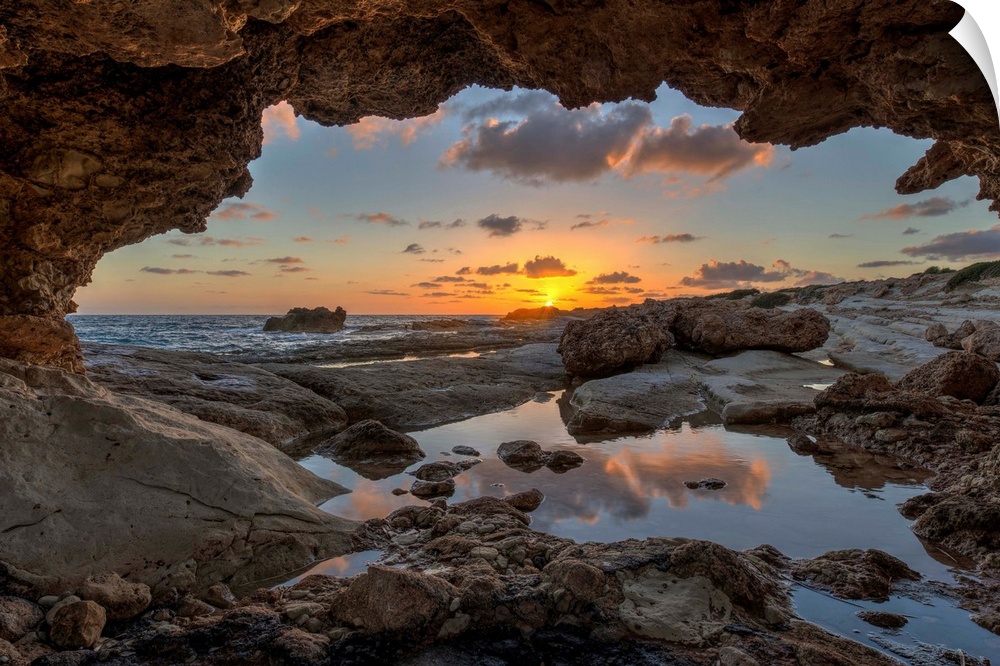 Sunset at the beach from inside a coastal cave in Paphos, Cyprus.