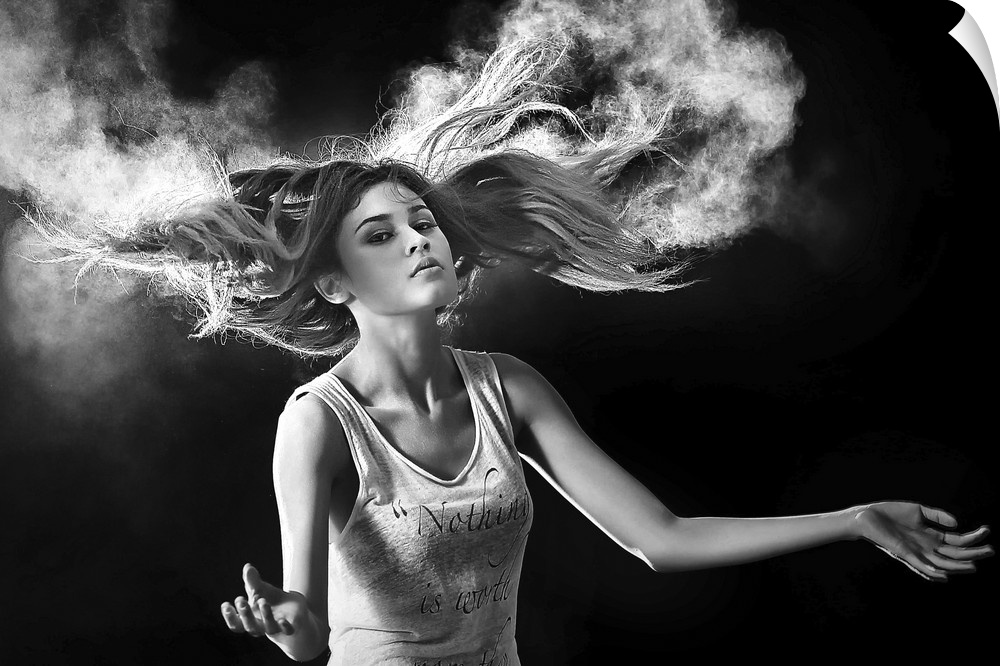 Black and white portrait of a beautiful woman with hair swirling around her.