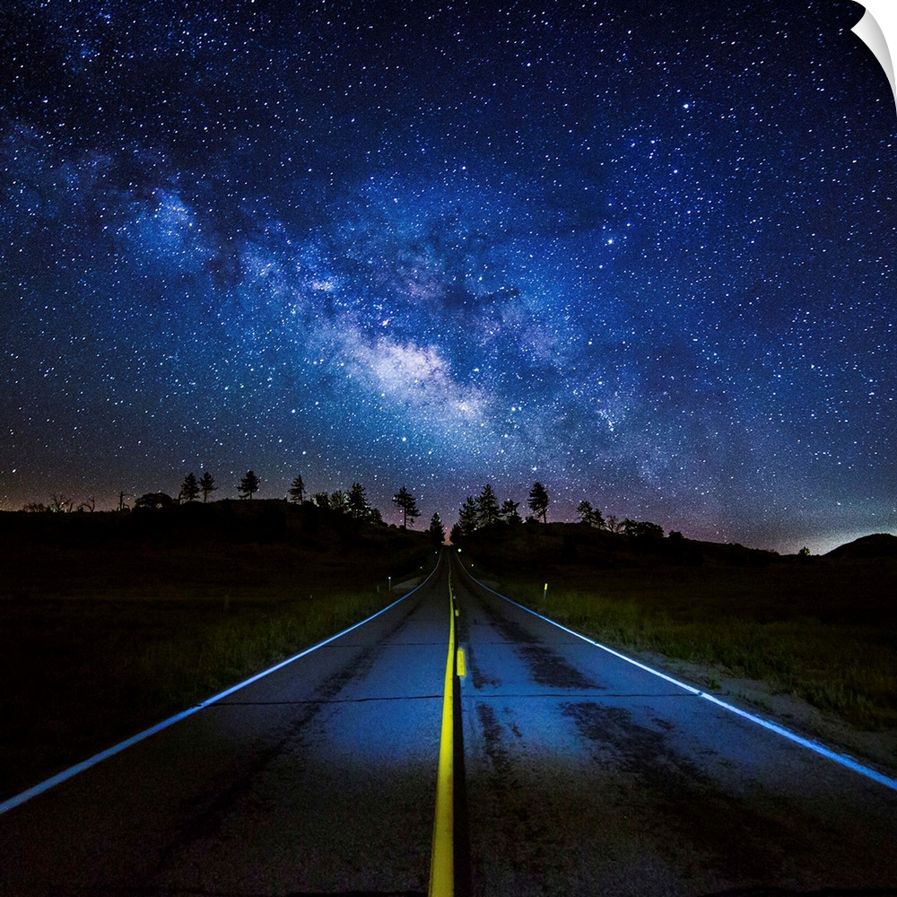 The Milky Way Galaxy visible in the night sky over a road.