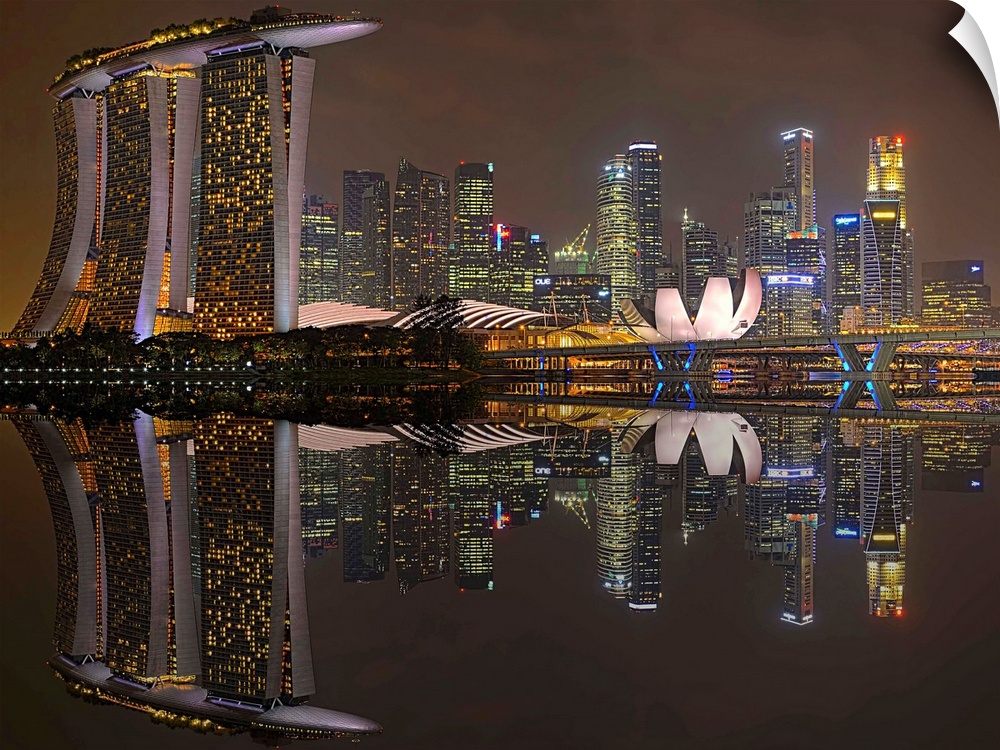 Skyscrapers in the city of Singapore at night, reflected in the waters of the marina.