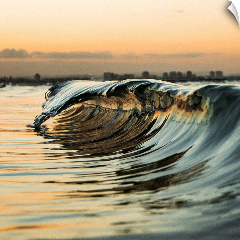 A "mini" wave off the coast at sunset.