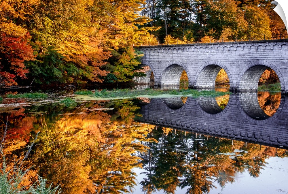 Stone arched bridge over a river in the fall, Massachusetts.