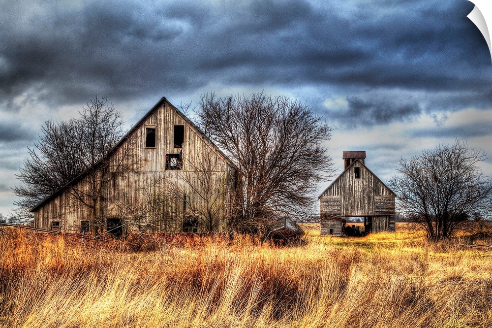 An image of two farm outbuildings under a dark and stormy sky.