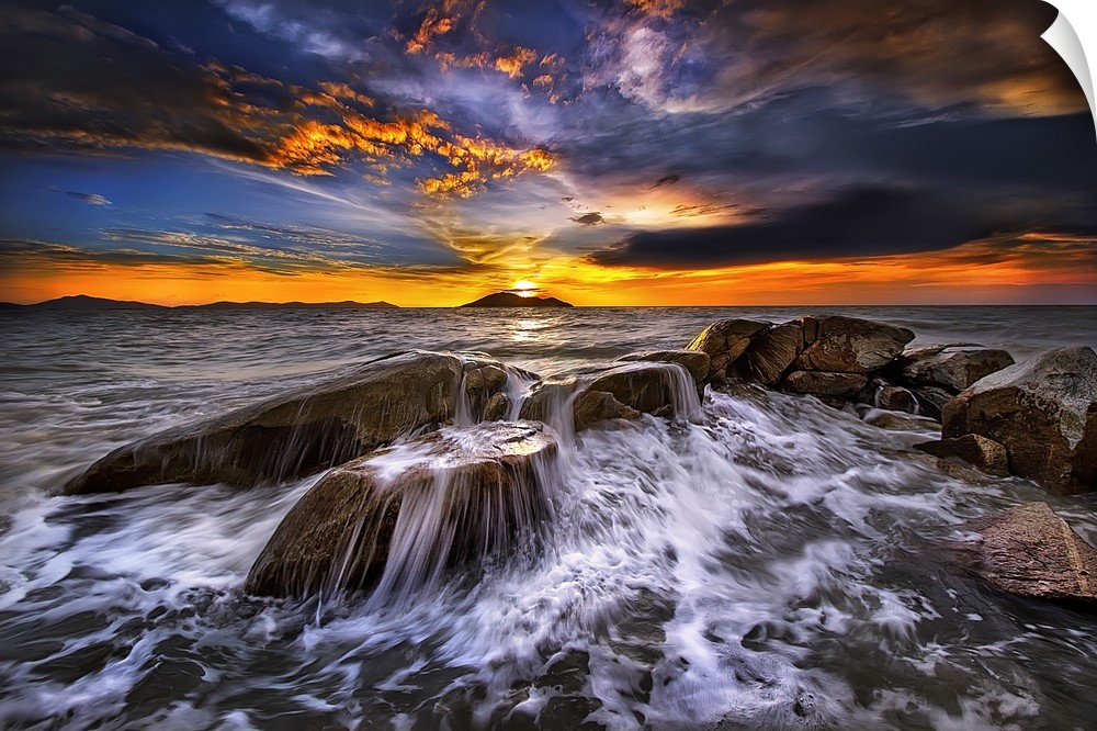 Photograph of a seascape at sunset with intense warm and cold clouds in the sky.