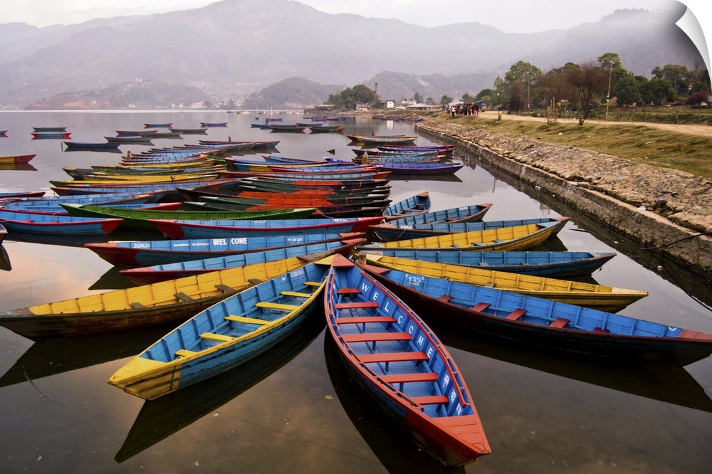 Long tail boats in star formations in a misty harbor in Nepal.