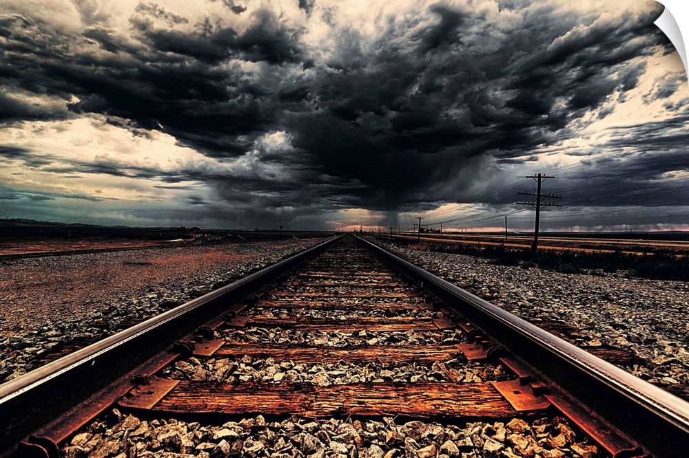 Dark storm clouds over iron railroad tracks.