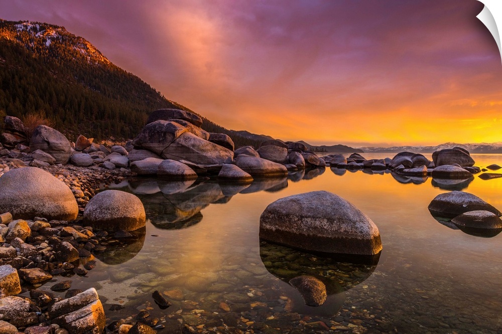 Round rocks in the shallow waters of Lake Tahoe in the Sierra Nevada Mountains at sunset.